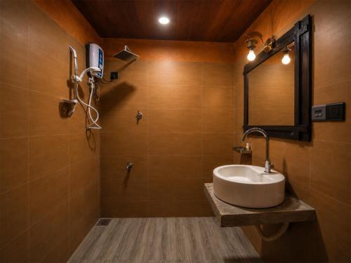 a bathroom with a sink and a mirror at Bathle Eco Resort in Mawanella