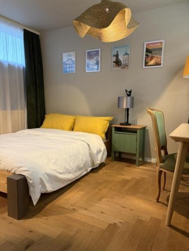 a bedroom with a bed and a table and a lamp at L Atelier Secret in Guebwiller