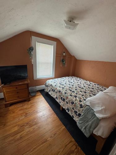 a bedroom with a bed and a television in it at Pet friendly cottage near Boston in Canton