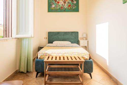 a small bedroom with a bed and a table at Los Flamingos in La Maddalena