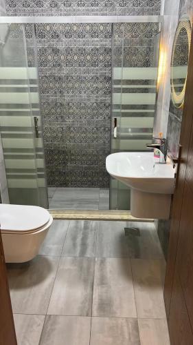 a bathroom with a toilet and a sink and a shower at The Mountain View in Ash Shāghūr