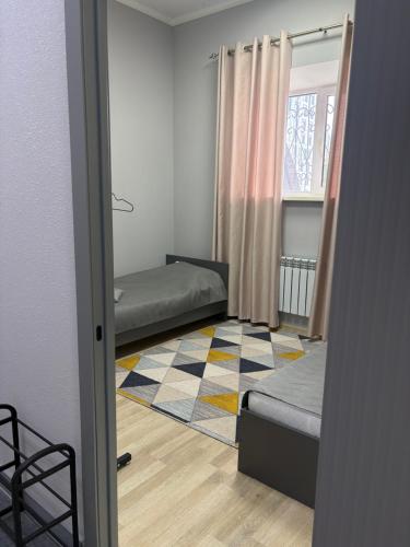 a room with two beds and a rug at Astana Rooms in Astana
