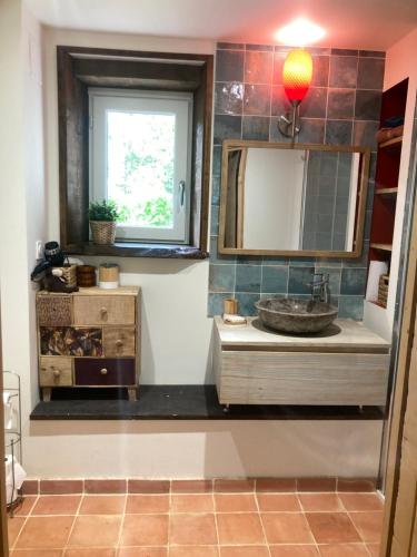 a bathroom with a sink and a mirror and a window at Appartement à colombages indépendant avec piscine partagée avec le proprietaire in Ponsan-Soubiran