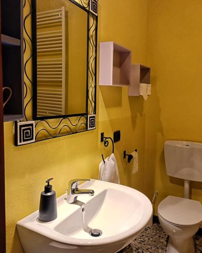 a bathroom with a sink and a toilet and a mirror at Bricc e Foss in San Desiderio