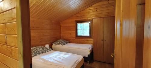 a small room with two beds in a cabin at Jaskolcze Gniazdo in Dziwnówek