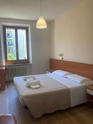 a bedroom with a large bed with two towels on it at Albergo Italia in Ancona