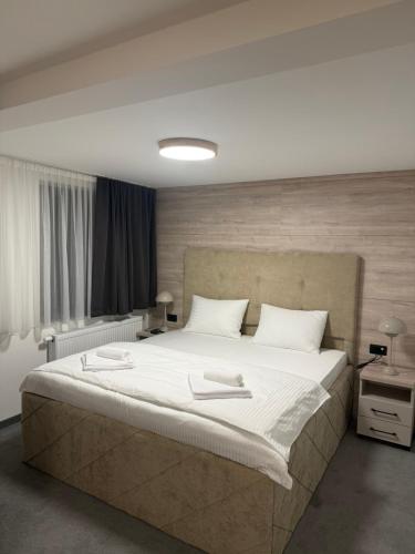a bedroom with a large bed with white sheets at Motel Gradina in Bosansko Grahovo