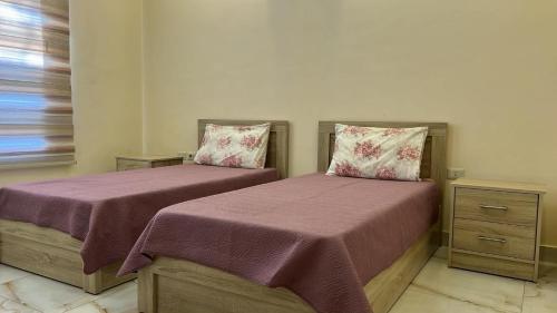 two beds sitting next to each other in a room at The Mountain View in Ash Shāghūr
