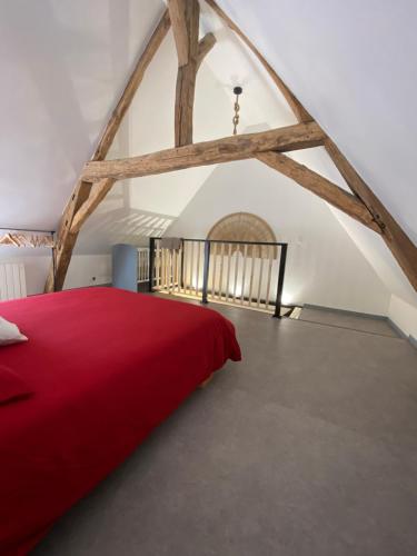 a bedroom with a red bed in a attic at Loft cosy 4 in city center in Saint-Benoît-sur-Loire