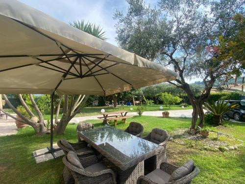 a table and chairs under a large umbrella at Un Passo Dal Mare in Lido di Fermo