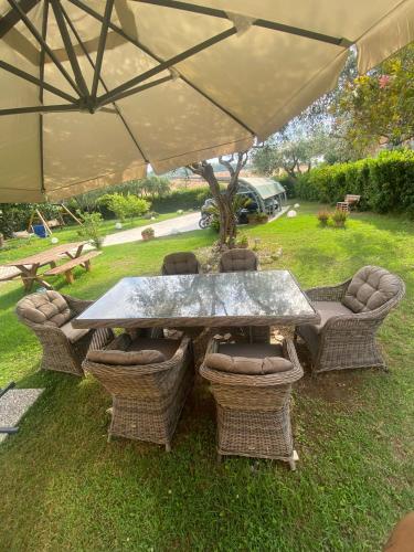 a table and chairs under an umbrella in a yard at Un Passo Dal Mare in Lido di Fermo