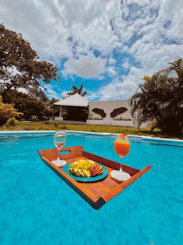 a tray of fruit and glasses on a table next to a swimming pool at Kooteja Aurora Coronado Nature Villa with Private Pool & Glamping Experience in Las Lajas