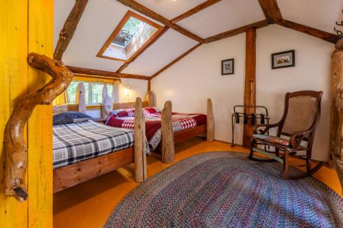 a bedroom with two beds and a chair at Woods End Landing in Bamfield