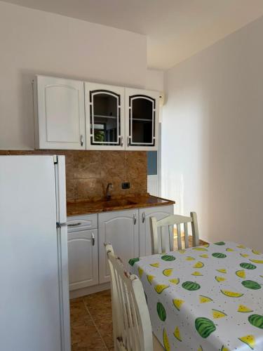 a kitchen with a table and a white refrigerator at Villa DEA in Velipojë