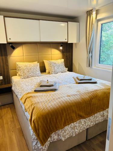 a bedroom with a large bed with two towels on it at Garden Lodge Obervellach in Obervellach