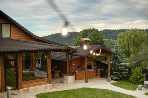 a house with an outdoor kitchen with a roof at Bizon Cabin in Albeștii de Muscel
