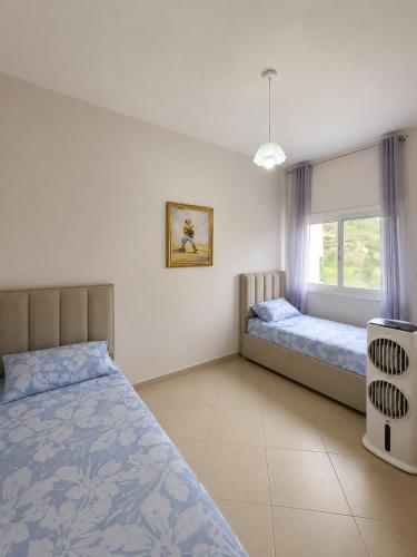 a bedroom with two beds and a window at At Konan's in Vlorë