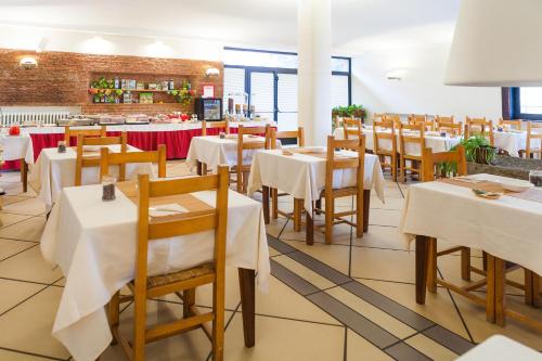 a restaurant with tables and chairs with white table cloth at Hotel Giardino in Breno