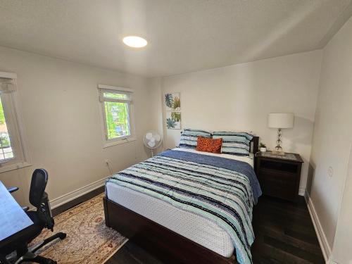 a bedroom with a bed and a desk and a chair at Cozy and comfortable home - Living room and Kitchen is shared in Pickering