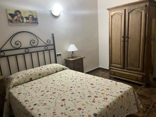 a bedroom with a bed and a wooden cabinet at Esencia plaza in Hornos