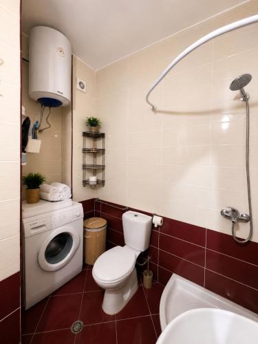 a bathroom with a toilet and a washing machine at At Konan's in Vlorë