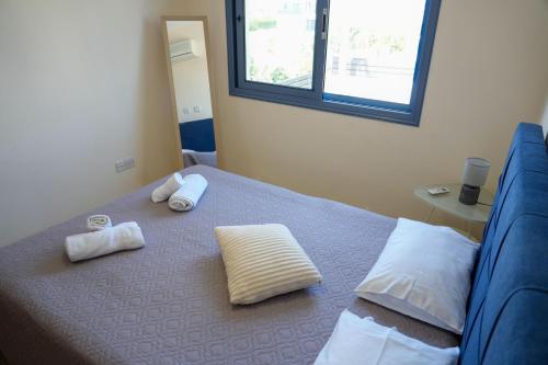 a bedroom with a bed with two towels on it at Villa Paradise Complex - Pyla Larnaca in Pyla
