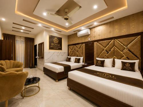 a hotel room with two beds and a chair at Royal Boutique Hotel Lahore in Lahore