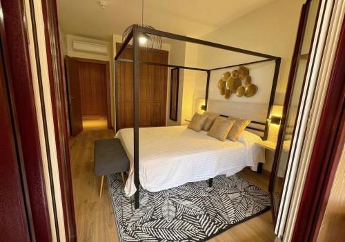 a bedroom with a canopy bed and a rug at Musa apartamentos in El Ejido