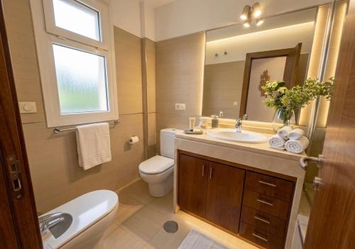 a bathroom with a sink and a toilet and a mirror at Musa apartamentos in El Ejido