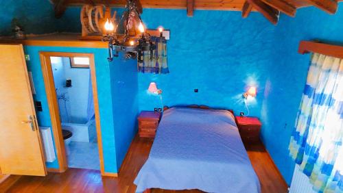 a blue bedroom with a bed and a blue wall at Villa Evmaria in Áyios Konstandínos
