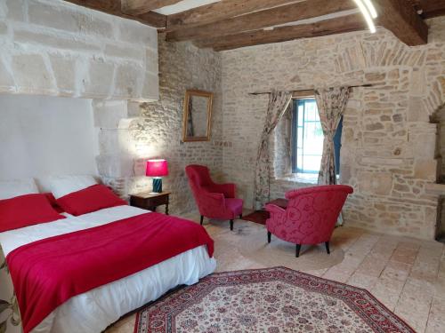 a bedroom with a red bed and two red chairs at Chambre entrée indépendante dans tour du 15ème siècle in Mauvières