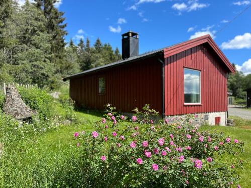 a red building with flowers in front of it at Cabin with great view close to town and ski area in Lillehammer