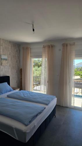 a bedroom with a bed and a large window at Villa DARIAN in Sukošan