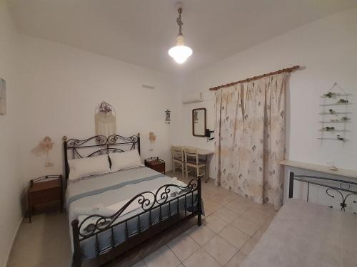 a bedroom with a bed and a table at Studios RENA in Fournoi