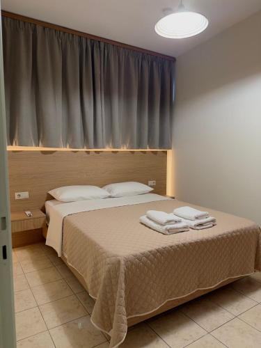 a bedroom with a bed with two towels on it at Litmus apartment 4 in Karlovasi