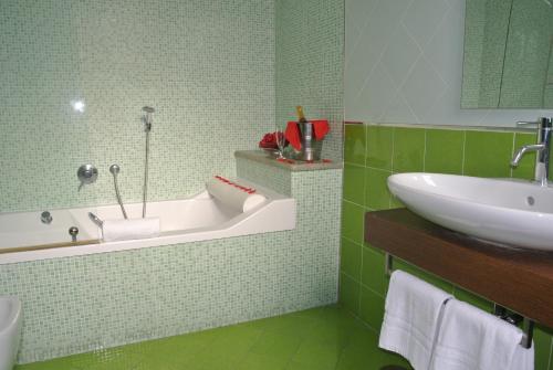 zieloną łazienkę z wanną i umywalką w obiekcie Hotel Stefano a Melito w mieście Melito di Napoli
