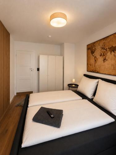 a bedroom with two beds with a remote control on the bed at Modernes Appartement mit Balkon & Parkplatz - Waldshut-Tiengen in Waldshut-Tiengen