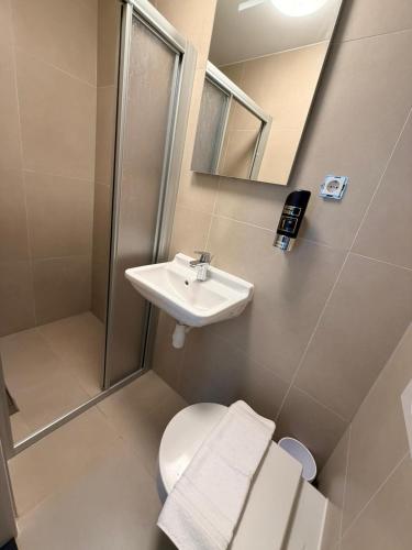 a bathroom with a sink and a toilet and a mirror at Hotel Continental Amsterdam in Amsterdam