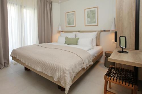 a bedroom with a large white bed and a desk at Casa Serena Bol in Bol