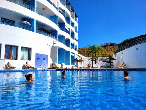 a group of people in a swimming pool next to a cruise ship at Appart Hôtel Cabo Dream in Cabo Negro
