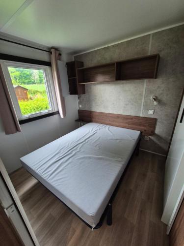 a bed in a small room with a window at Mobil home Salsa in Litteau