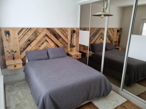 a bedroom with two beds and a mirror at Beautiful ground floor 2 bed flat in Camberley