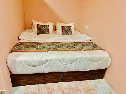 a large bed in a corner of a room at Hotel Avigatkabir sanwer in Sānwer