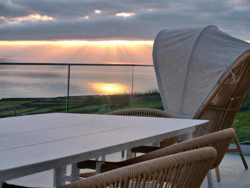 a white table and chairs with a view of the ocean at Casa Conchita in Angra do Heroísmo