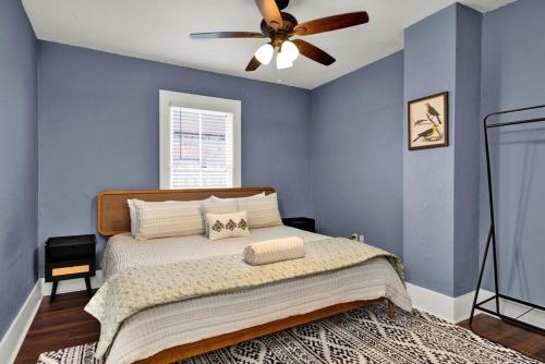 a bedroom with blue walls and a bed with a ceiling fan at Cedar Street Retreat - Unit C in St. Augustine
