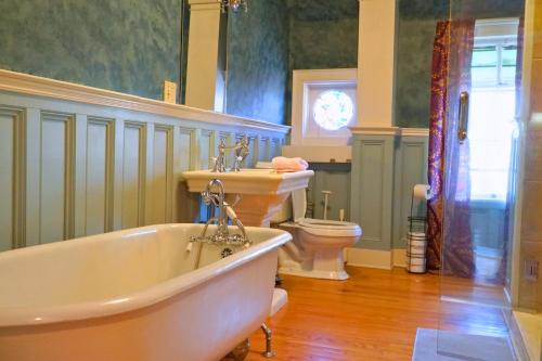 a bathroom with a tub and a sink and a toilet at The Sanctuary on Washington in Norwich