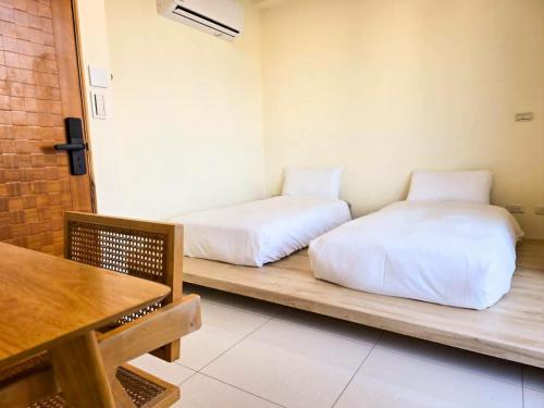 two beds sitting on a wooden bench in a room at 日子有光 SHINE Inn Day in Hengchun South Gate