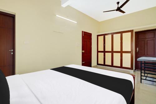 a bedroom with a bed and a ceiling fan at Hotel O Nakshathra Inn in Kazhakuttam