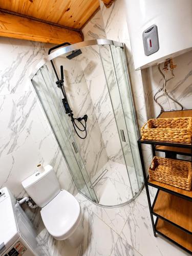a bathroom with a toilet and a glass shower at Radawski Chill in Radawa