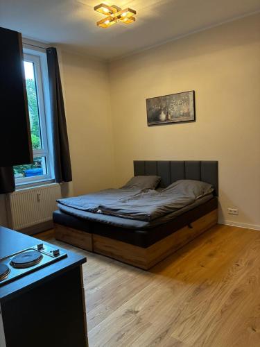 a bedroom with a bed and a desk and a window at Gästehaus Lelo 1 in Solingen